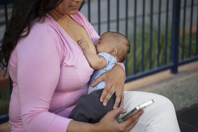 1_side-view-mother-breastfeeding-outdoors-67355240