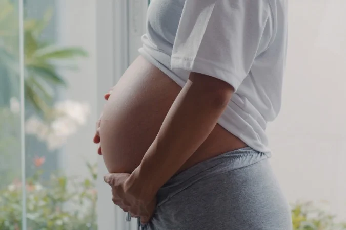 1_young-asian-pregnant-woman-holding-her-belly-talking-with-her-child-mom-feeling-happy-smiling-positive-peaceful-while-take-care-baby-pregnancy-near-window-living-room-home--1--67509407